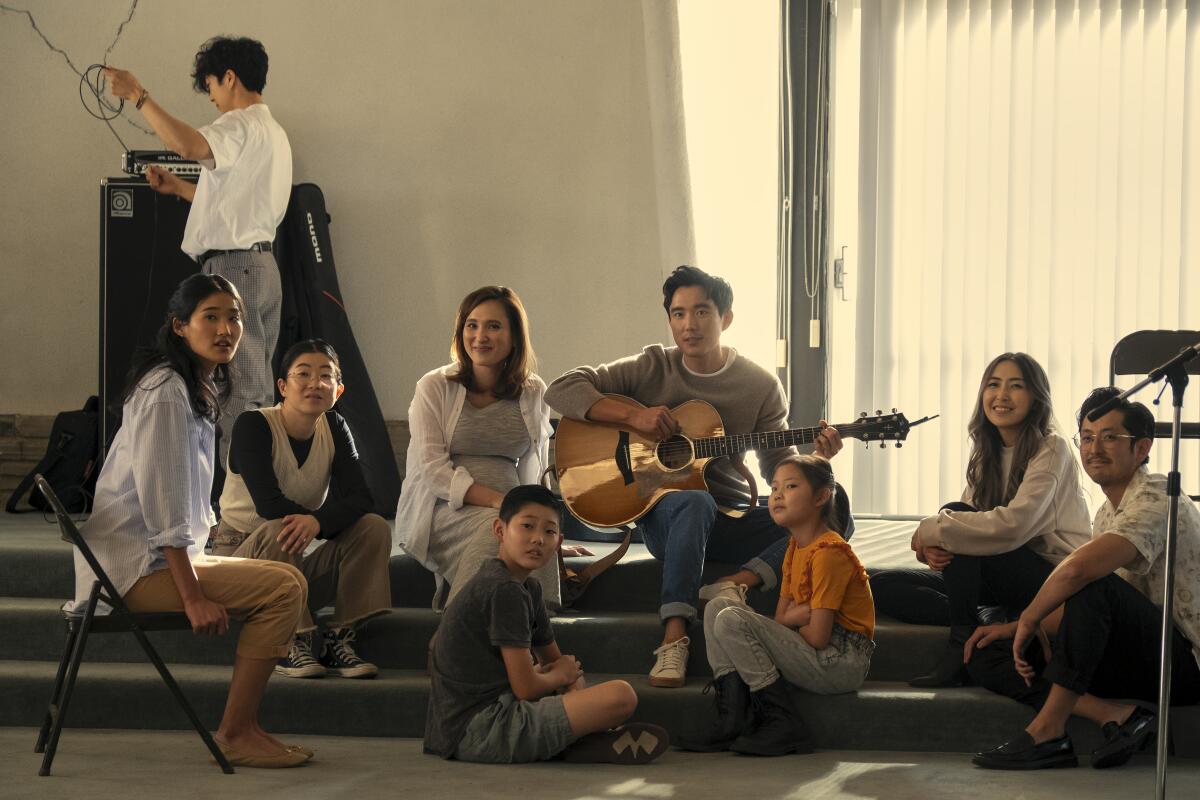 Three adults lead a group of student musicians.