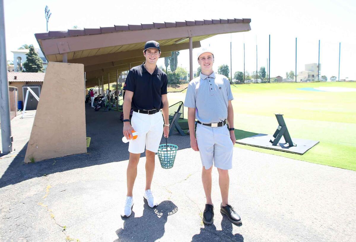 San Diego State University golfer Quentin Hill, and his friend Dylan Walsh, from left, are happy to be back practicing on the range at the Newport Beach Golf Course on Friday.