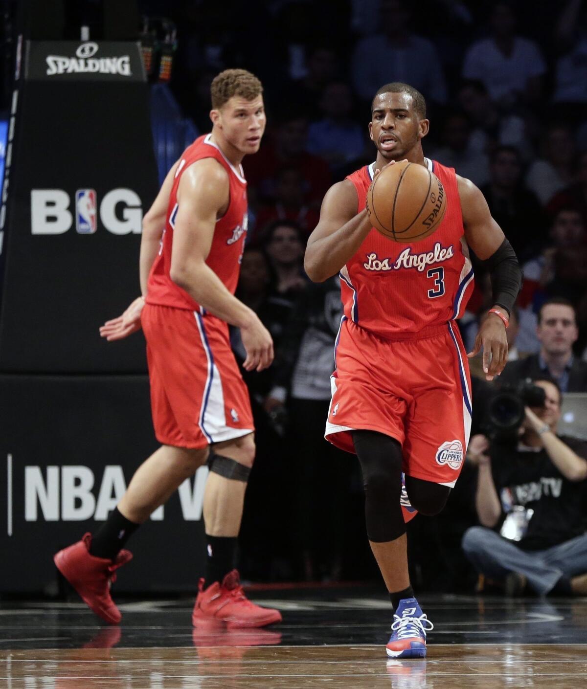 Clippers point guard Chris Paul, right, dribbles the ball ahead of teammate Blake Griffin during the Clippers' 102-93 loss to the Brooklyn Nets.