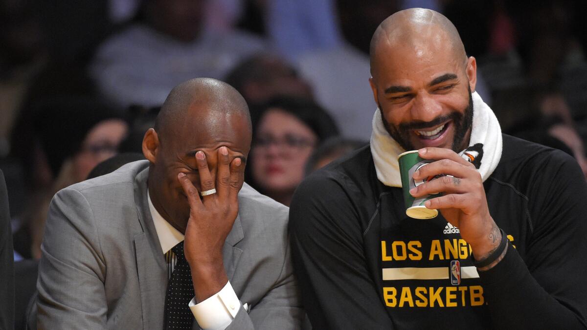 Injured Lakers star Kobe Bryant and forward Carlos Boozer laugh on the bench during a win over the Minnesota Timberwolves at Staples Center on April 10.