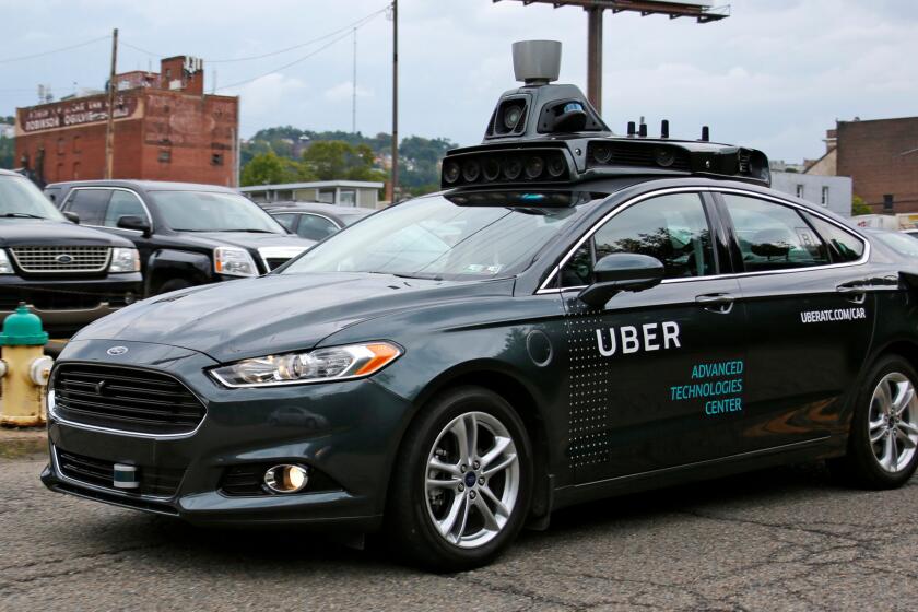 A self-driving Uber car makes its way down River Road in Pittsburgh on Sept. 14.