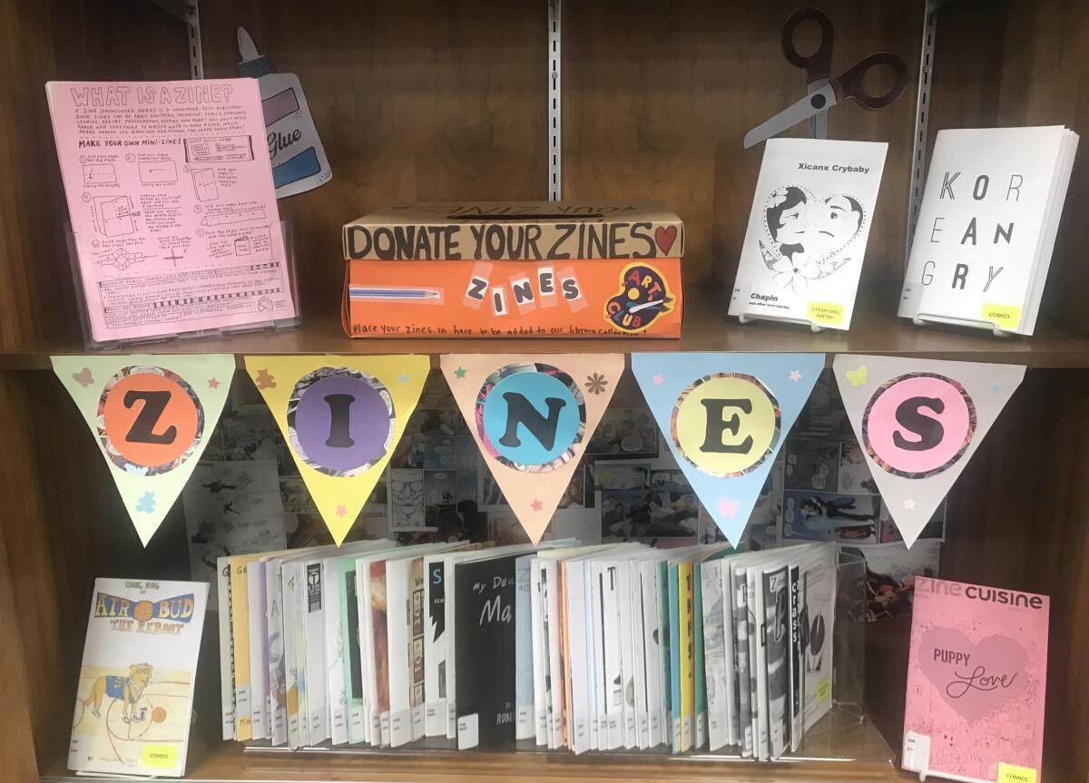 A collection of zines fill a shelf at the Anaheim Central Library. This year's O.C. Zine Fest will be held online.
