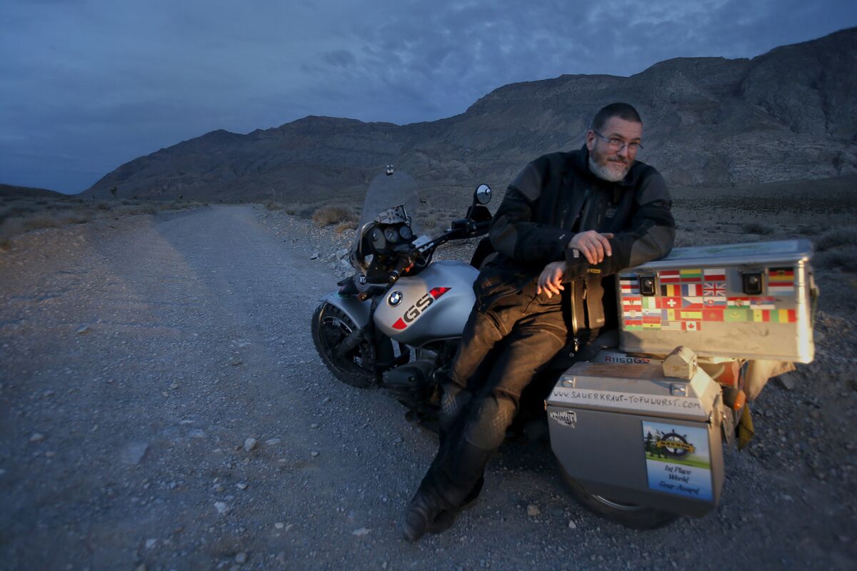 Vegan biker blogger Wolfgang Steffens, 49, sits across the saddle of his broken-down BMW motorcycle (with sidecar) on Racetrack Road, one of the roughest roads in the outback of Death Valley.