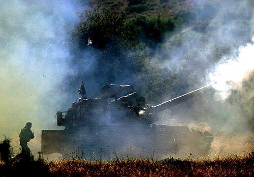 An Israeli soldier runs to reload an Israeli heavy artillery piece after it fired toward targets in southern Lebanon.
