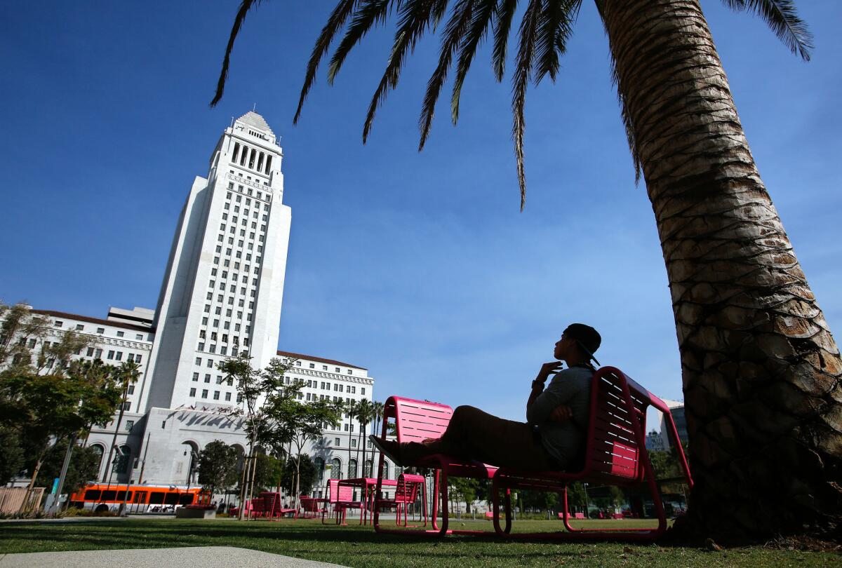 Rene Garcia, of Huntington Park, looks toward City Hall while relaxing in Grand Park.
