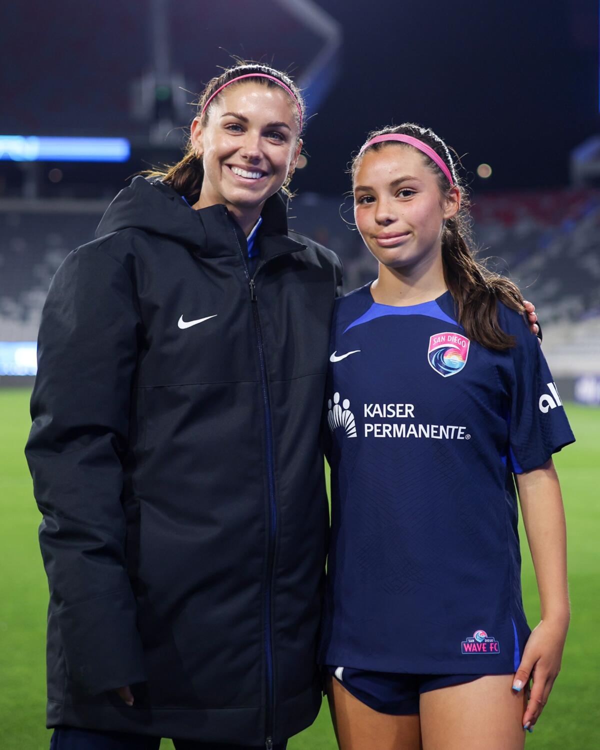 Alex Morgan (izq.) posa junto a Melanie Barcenas después de un encuentro con el Wave FC.