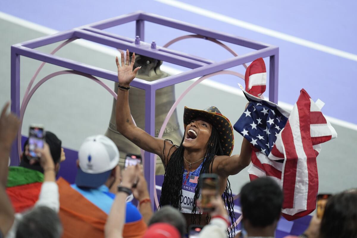 American Tara Davis-Woodhall wears a cowboy hat and waves a U.S. flag while celebrating winning gold in the long jump