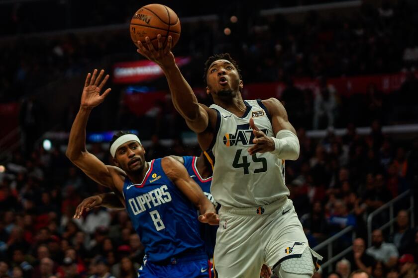 LOS ANGELES, CALIF. - NOVEMBER 03: Utah Jazz guard Donovan Mitchell (45) goes for a layup attempt while being defended by LA Clippers forward Maurice Harkless (8) during a NBA game between the Utah Jazz and the LA Clippers at Staples Center on Sunday, Nov. 3, 2019 in Los Angeles, Calif. (Kent Nishimura / Los Angeles Times)