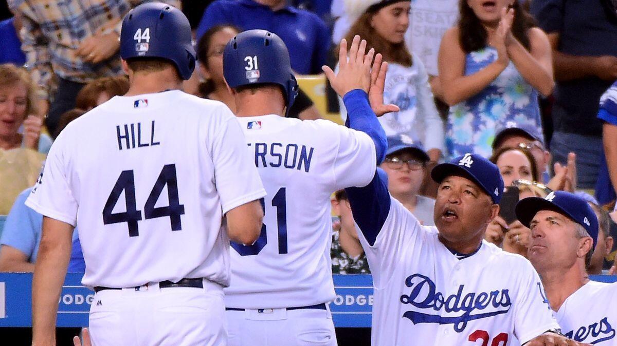 Dodgers manager Dave Roberts (30) celebrates with Joc Pederson's (31) and Rich Hill (44) after the Dodgers tie the game at 1-1 against the New York Mets, Wednesday.