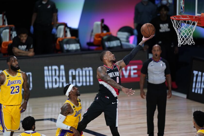 Portland's Damian Lillard scores on a layup against the Lakers in the first half.