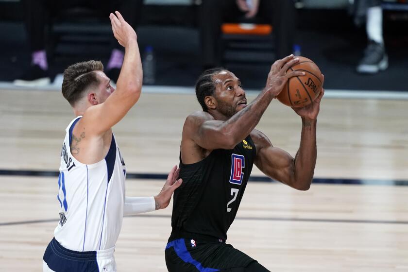 Clippers' Kawhi Leonard drives past Dallas Mavericks' Luka Doncic.