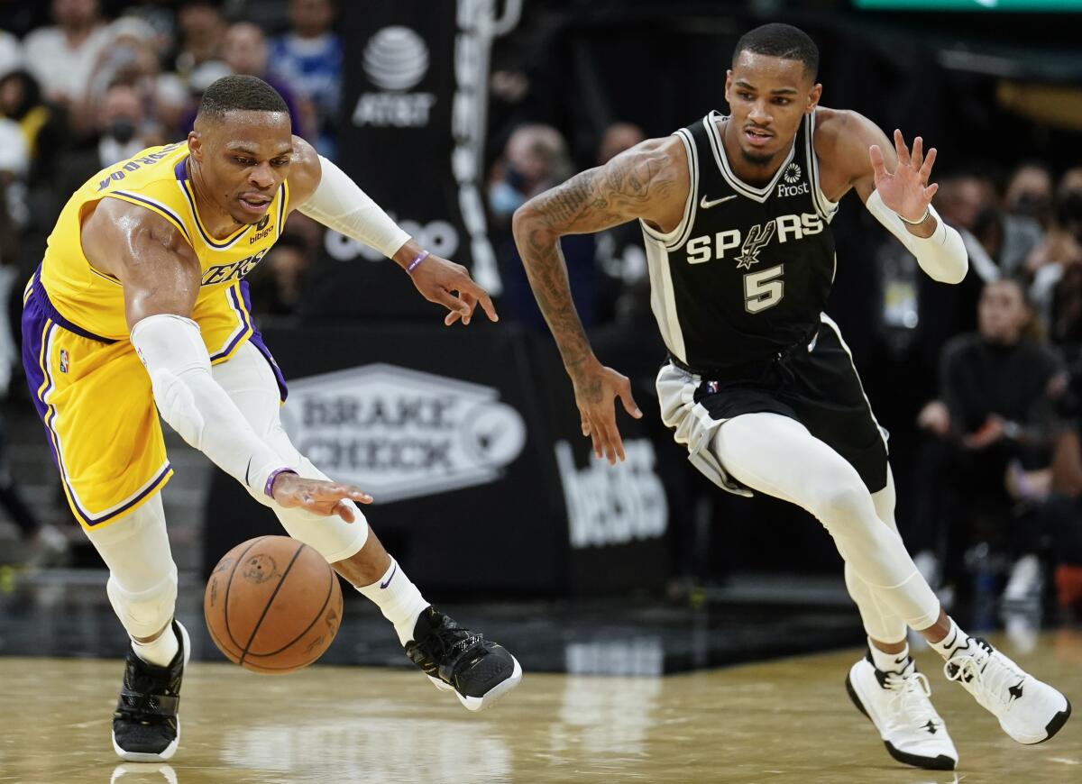 Lakers' Russell Westbrook and San Antonio Spurs' Dejounte Murray chase the ball.