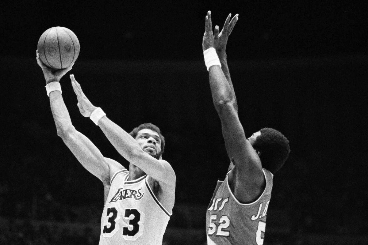 FILE - Los Angeles Lakers' Kareem Abdul-Jabbar (33) hooks a shot over Portland Trail Blazers' Jim Brewer (52) during the first half of an NBA basketball game in Los Angeles on March 12, 1980. Abdul-Jabbar wins his sixth MVP award after claiming five in the 1970s. He averaged 24.8 points, 10.8 rebounds and 3.4 blocks. (AP Photo/Lennox McLendon, File)