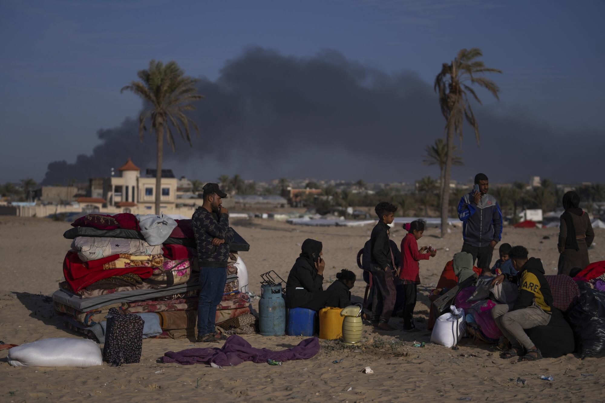 Gazans gather outside with their belongings in Rafah