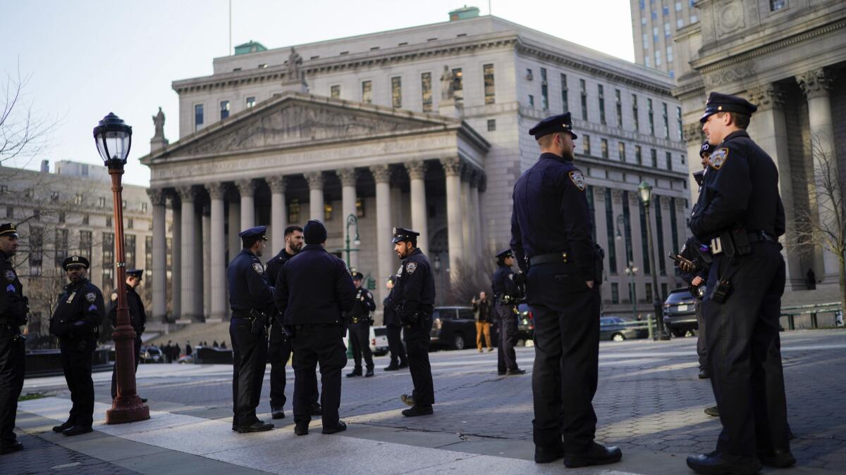 In New York, police officers wait for instructions around a courthouse.