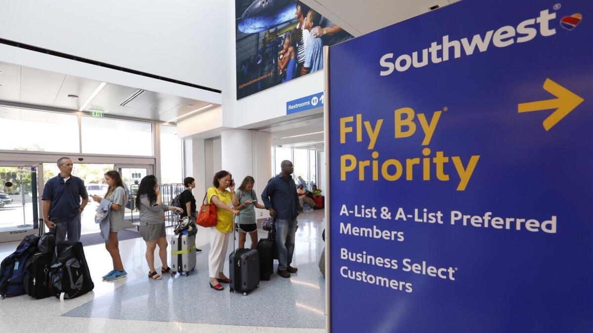 Passengers line up at the Southwest Airlines ticket counter at Los Angeles International Airport. The airline is raising its early boarding fee from $15 to as much as $25, depending on the popularity and length of the flight.