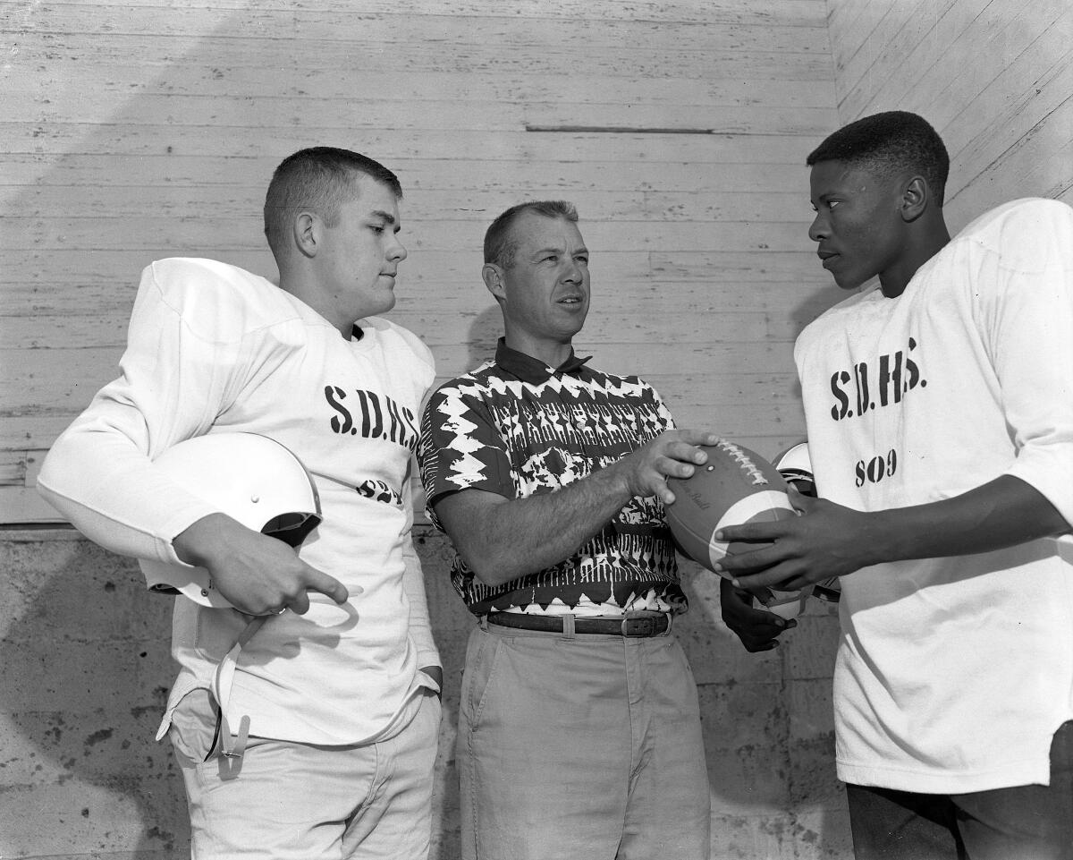 San Diego High football coach Duane Maley (middle) talks to his his players Roy Pharis (left) and Willie McCloud in 195.