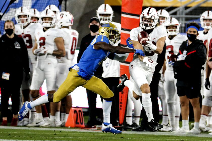 Stanford wide receiver Simi Fehoko catches a pass while UCLA defensive back Jay Shaw defends Dec. 19, 2020.