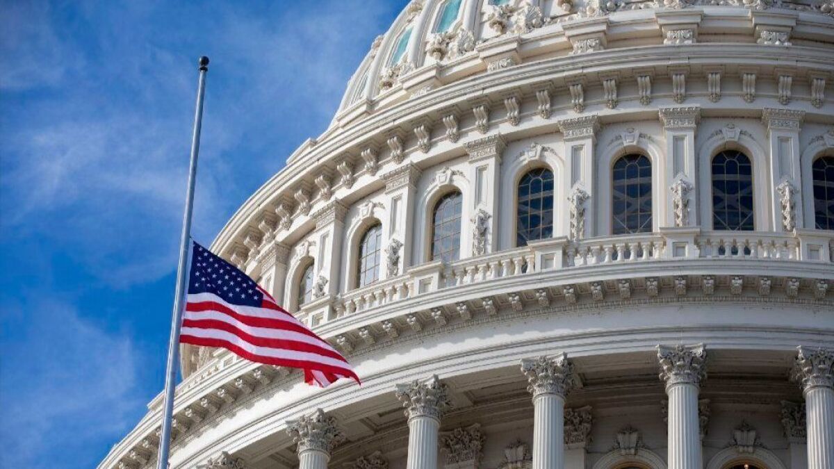In honor of former President George H.W. Bush, the U.S. flag flies at half-staff outside the U.S. Capitol in Washington.