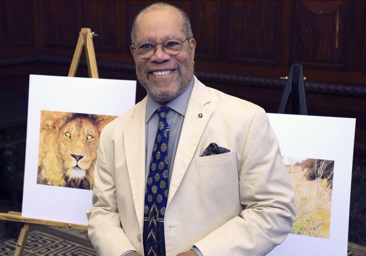 Children's book illustrator Jerry Pinkney in front of two of his illustrations at City Hall in Philadelphia in 2016.