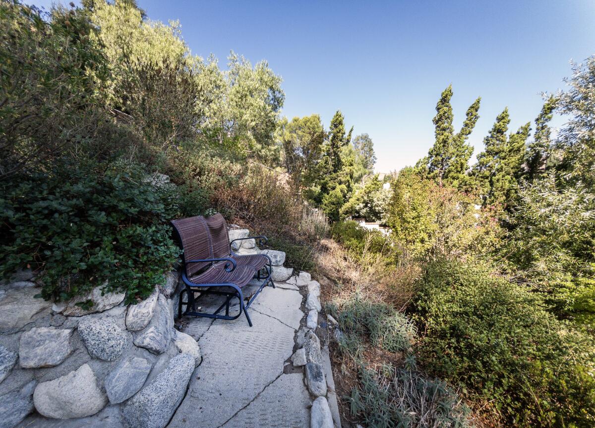 Hillside seating on stone-lined concrete path at Phil and Margaret Hinch's Porter Ranch backyard.