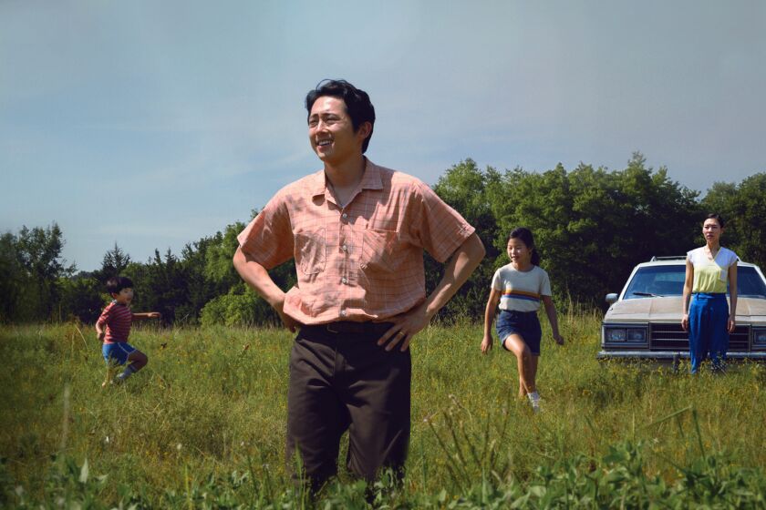 Steven Yeun standing in a scene from "Minari"