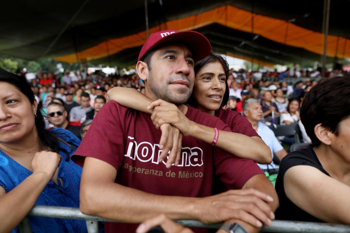 Miguel Gomez Torres, center, and his wife, Emma, listen while Andres Manuel Lopez Obrador, the front-runner in Mexico's presidential race, speaks at a National Regeneration Movement campaign rally.