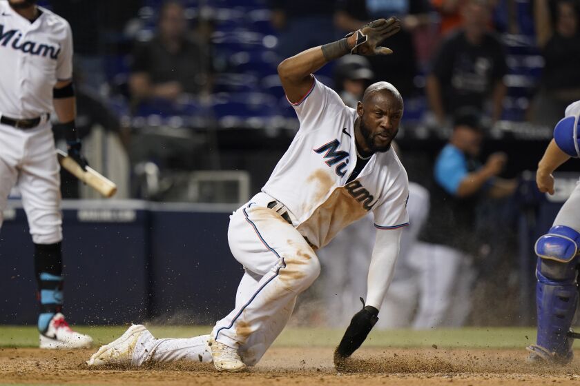 Miami Marlins' Starling Marte slides into home to score on a throwing error by Los Angeles Dodgers catcher Will Smith after a wild pitch during the 10th inning of a baseball game Tuesday, July 6, 2021, in Miami. The Marlins won 2-1 in 10 innings. (AP Photo/Wilfredo Lee)