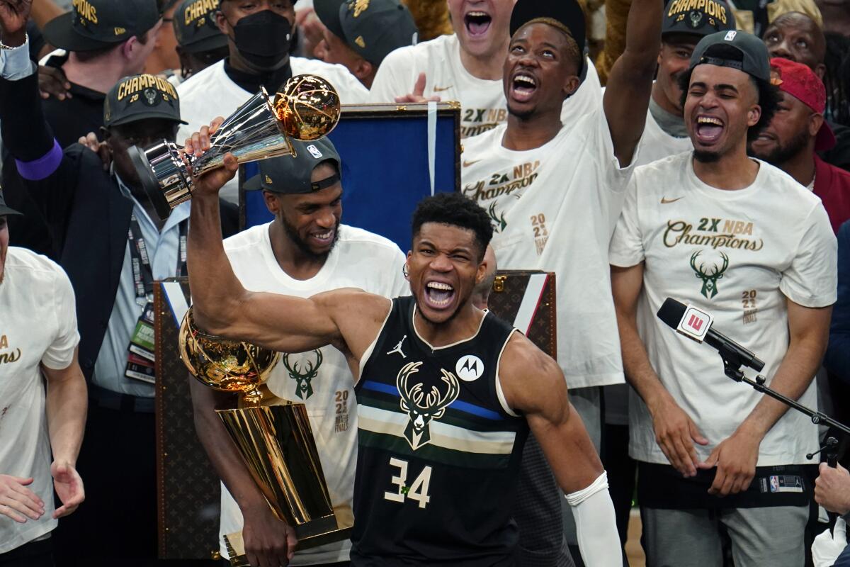 Milwaukee Bucks forward Giannis Antetokounmpo reacts with the championship trophy.