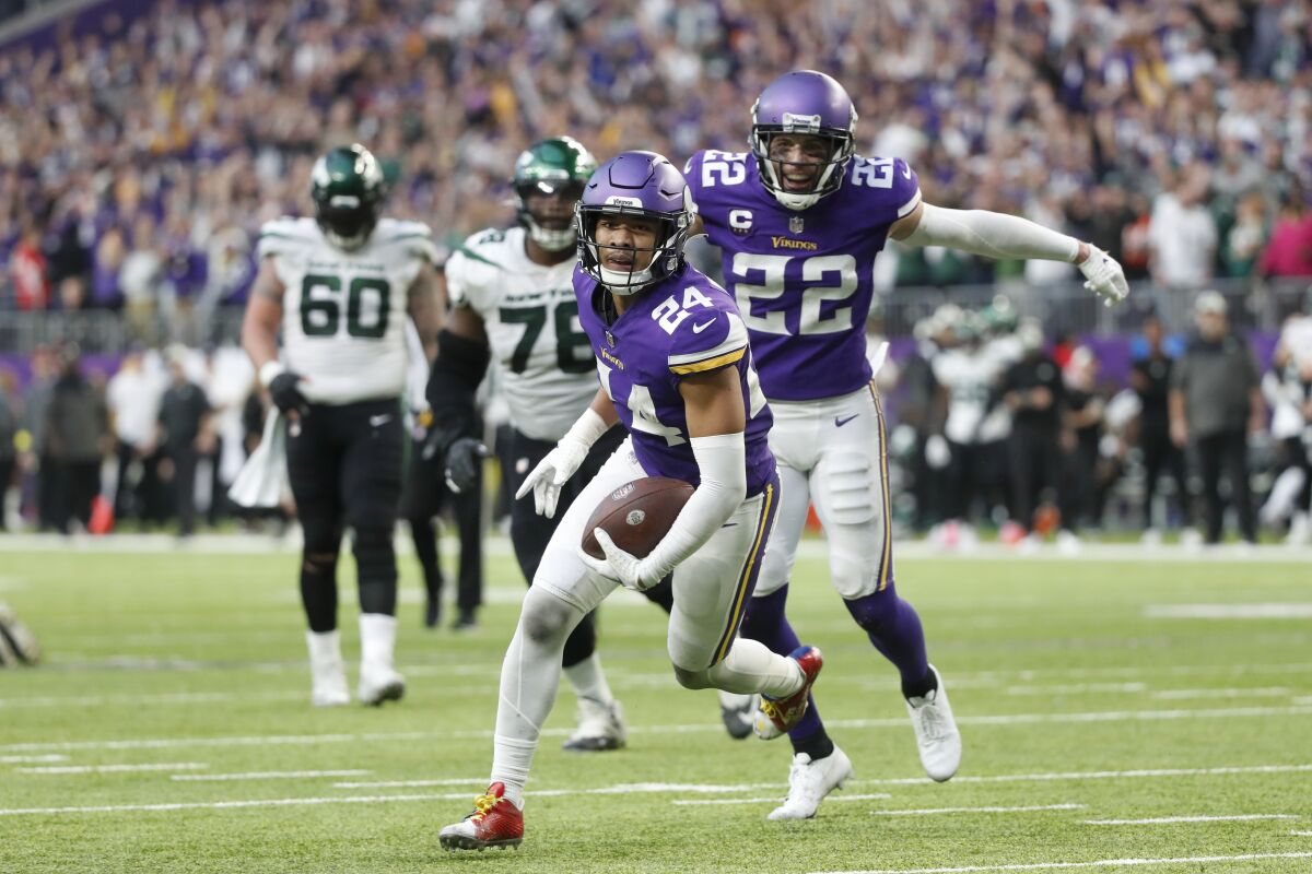 Minnesota Vikings safety Camryn Bynum (24) celebrates with teammate safety Harrison Smith (22) after intercepting a pass during the second half of an NFL football game against the New York Jets, Sunday, Dec. 4, 2022, in Minneapolis. The Vikings won 27-22. (AP Photo/Bruce Kluckhohn)