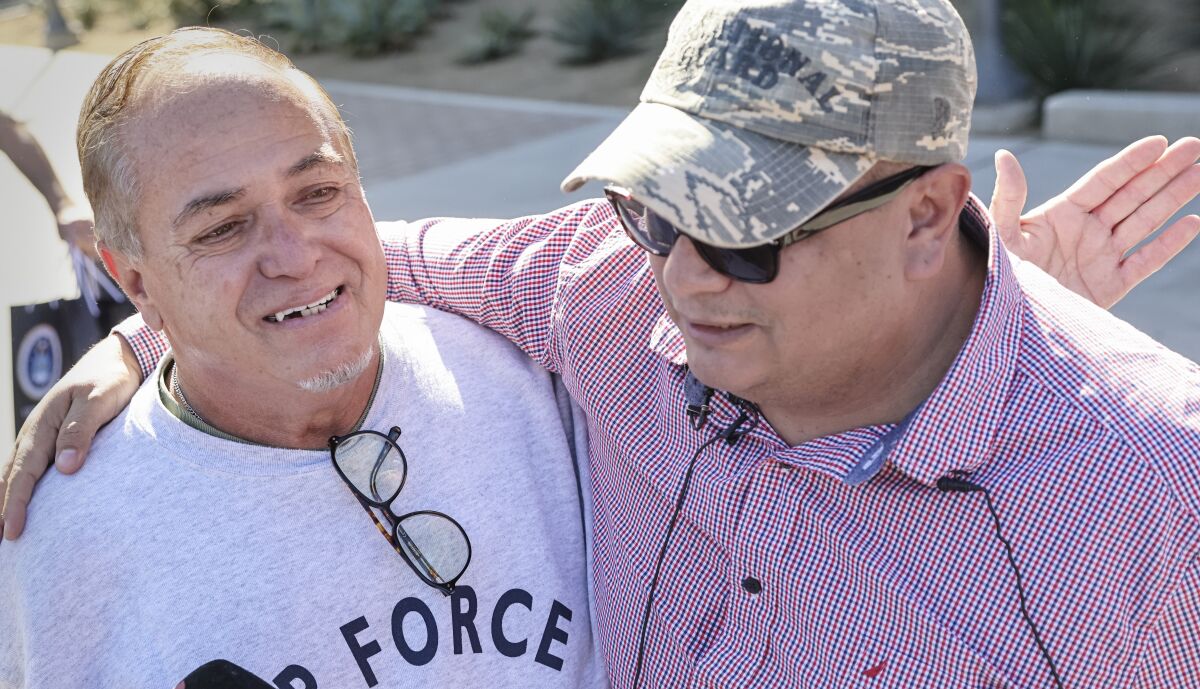 Robert Vivar (left) gets a hug from his son, an Air Force veteran also named Robert Vivar (right)