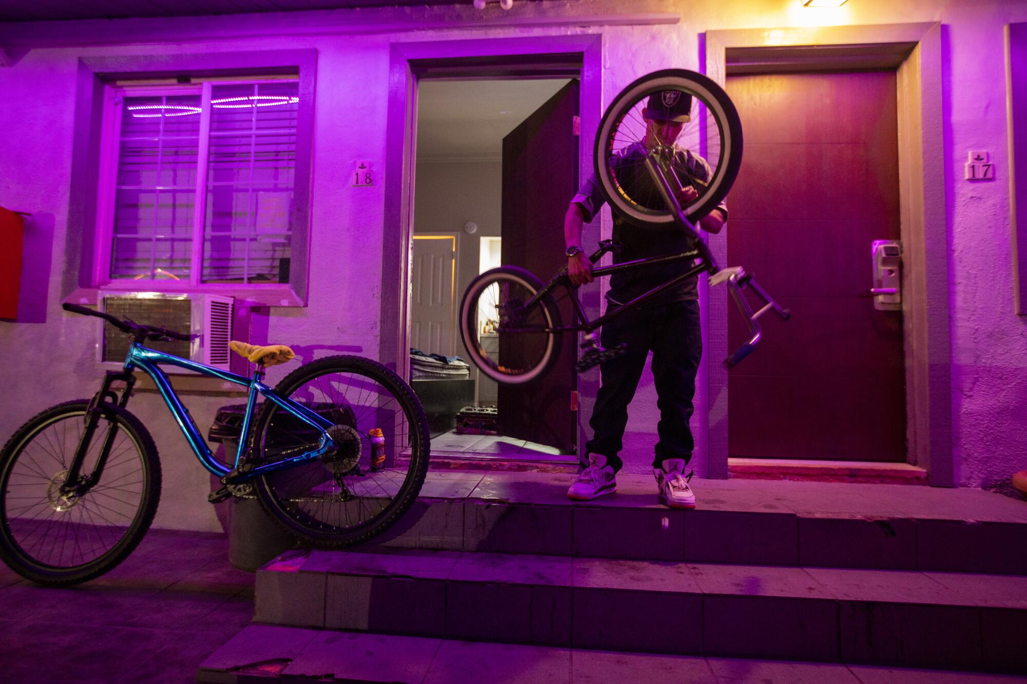 Mario Arciga works on his bikes on the steps outside his room at the Desert Moon Motel.