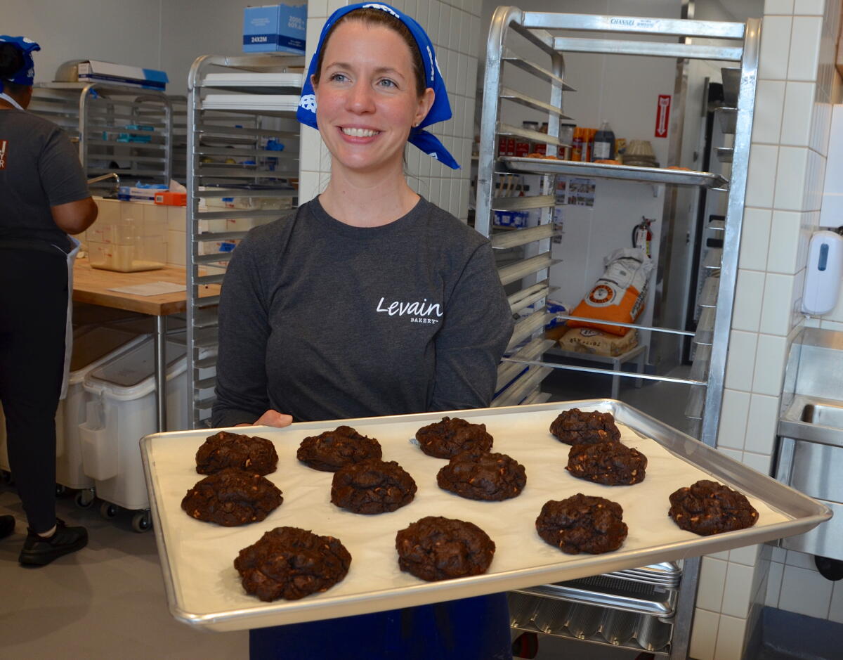 Annie Stachewicz removes freshly baked chocolate- peanut butter cookies from the oven at Levain Bakery in Newport Beach.