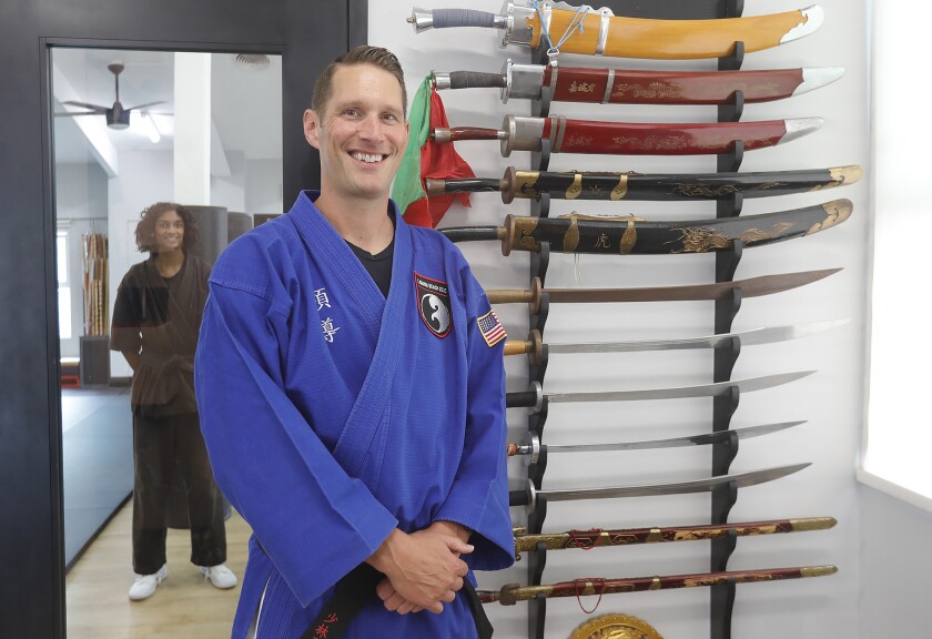 Master Jeff Kash stands next to a collection of swords in his Laguna Beach Dojo studio in Laguna Beach.