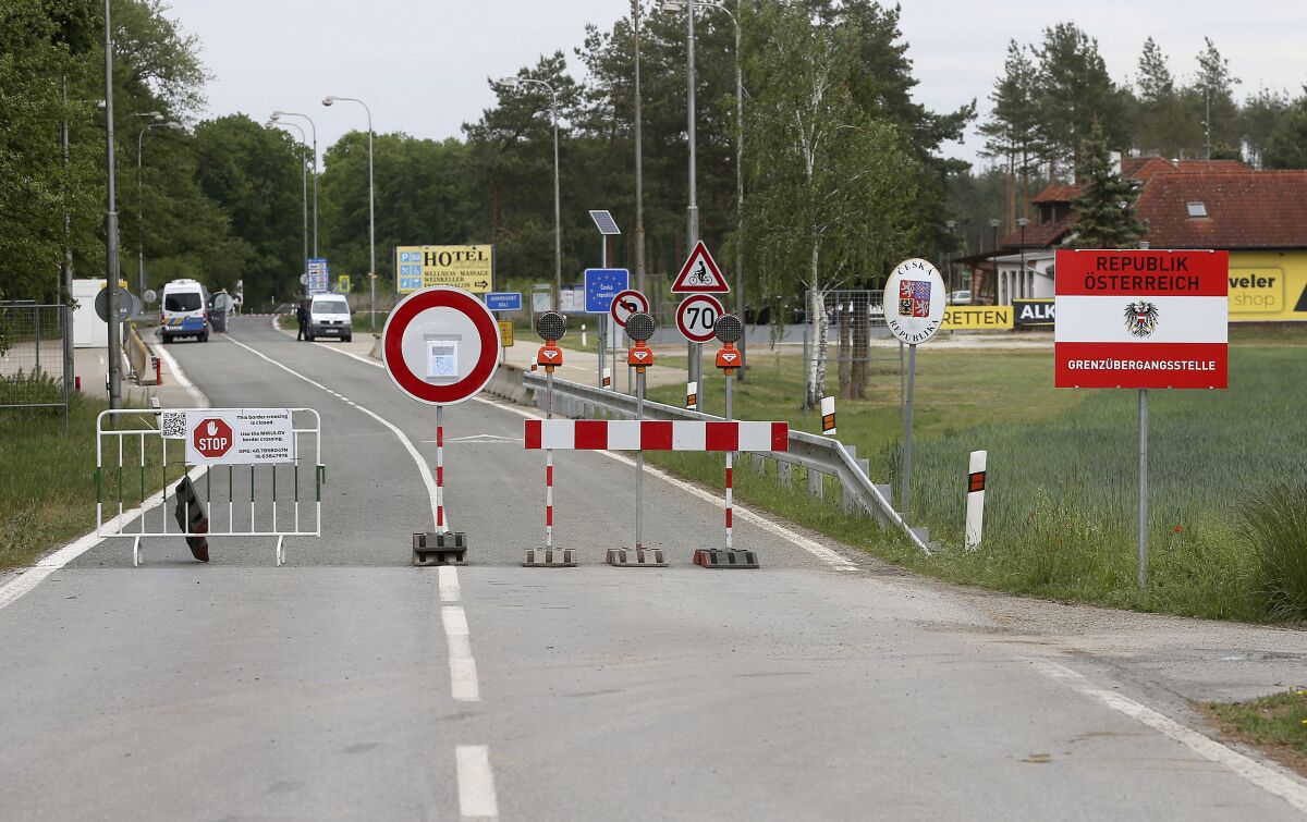 FILE - In this May 13, 2020 file photo, a barrier blocks the road at the closed border crossing from Austria to the Czech Republic near Reinthal, Austria. European Union countries are set to adopt a common traffic light system to coordinate traveling across the 27-nation bloc, but a return to a full freedom of movement in the midst of the COVID-19 pandemic remains far from reach. (AP Photo/Ronald Zak, File)