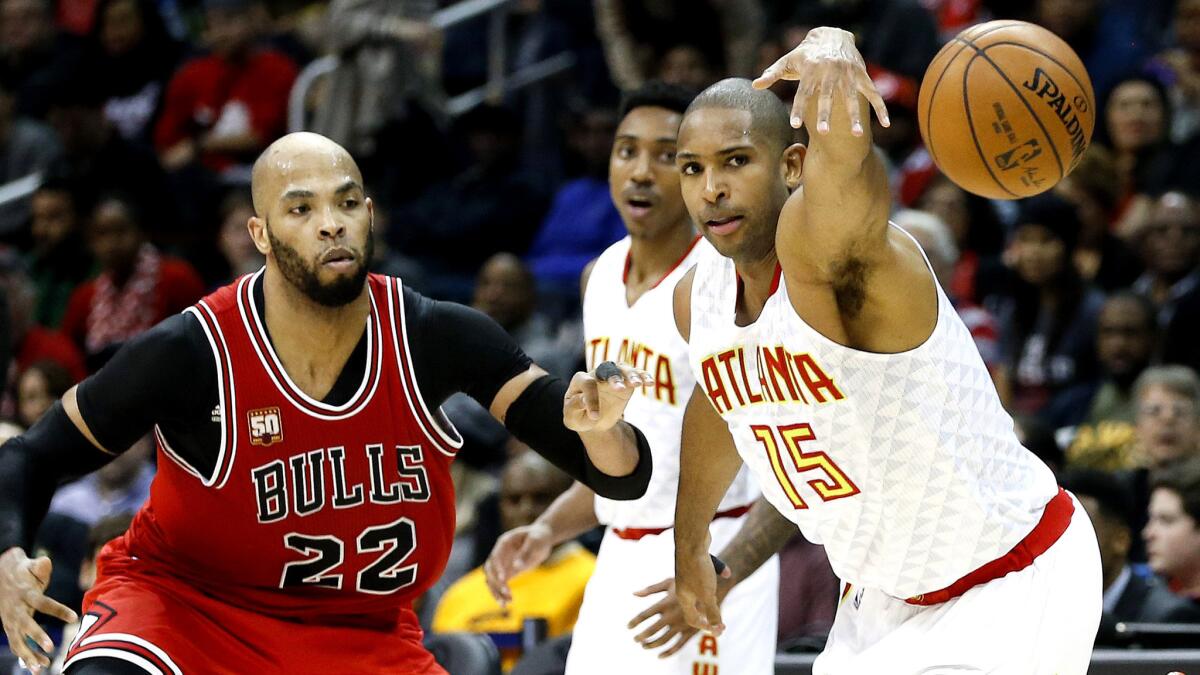 Hawks center Al Horford (15) chases down a loose ball against Bulls forward Taj Gibson (22) in the first half Saturday.