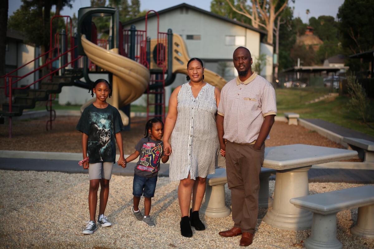 A family of four standing in a playground area