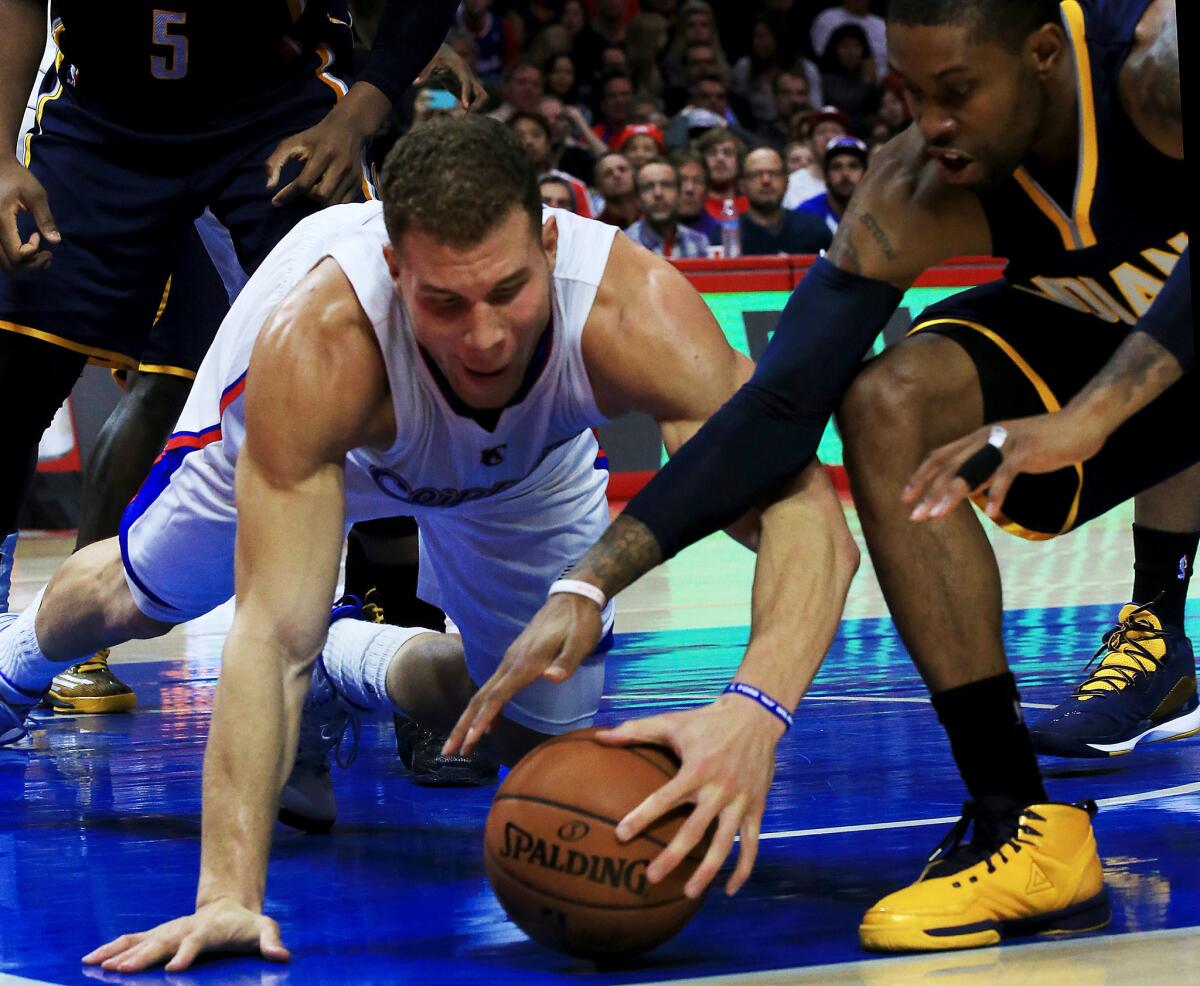 Clippers forward Blake Griffin battles for a loose ball against Indiana Pacers guard C.J. Watson during a Dec. 17 game at Staples Center