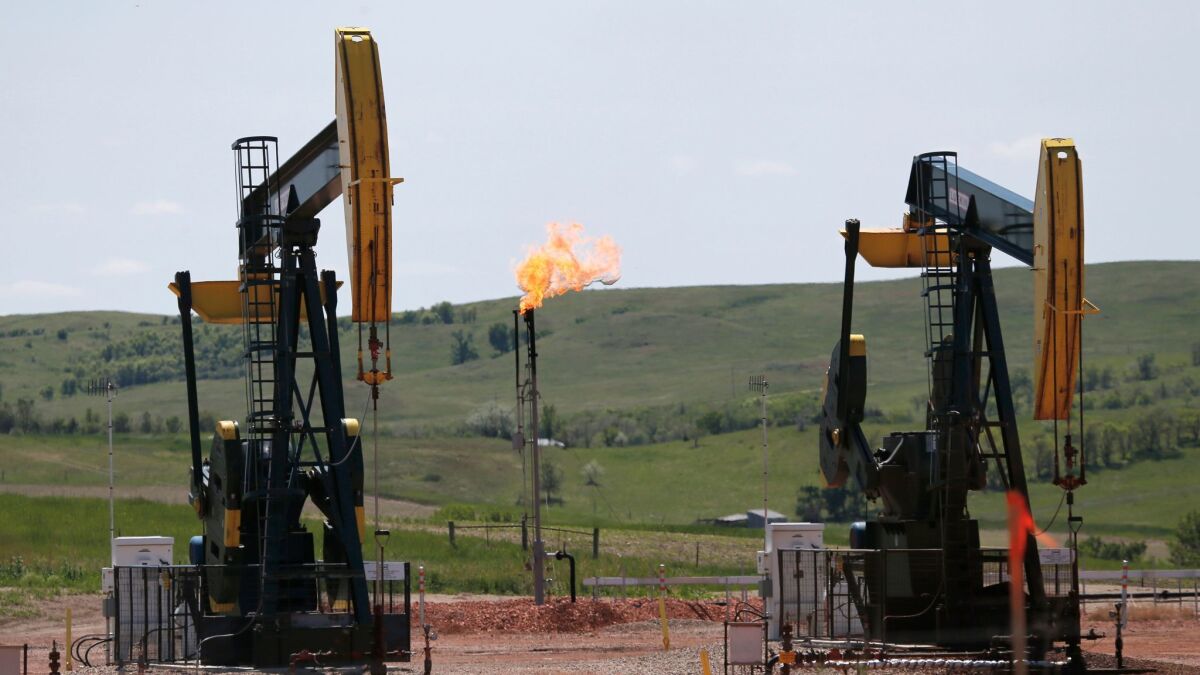 Oil pumps and natural gas burn off in Watford City, N.D. on June 12, 2014.