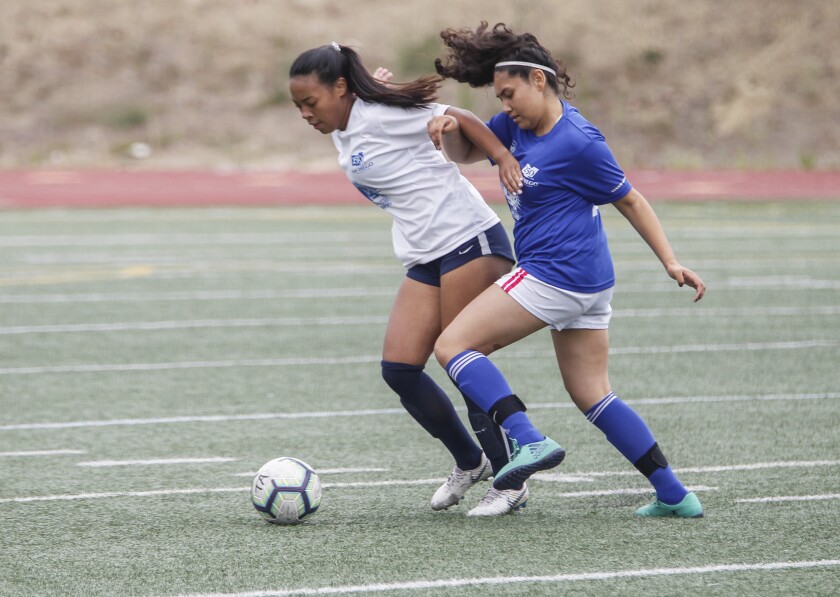 San Diego’s Juliet Quinney (left) and Tijuana’s Camila Loaiza battle for the ball Tuesday in the Sister City All-Star Soccer Tournament at Balboa Stadium.