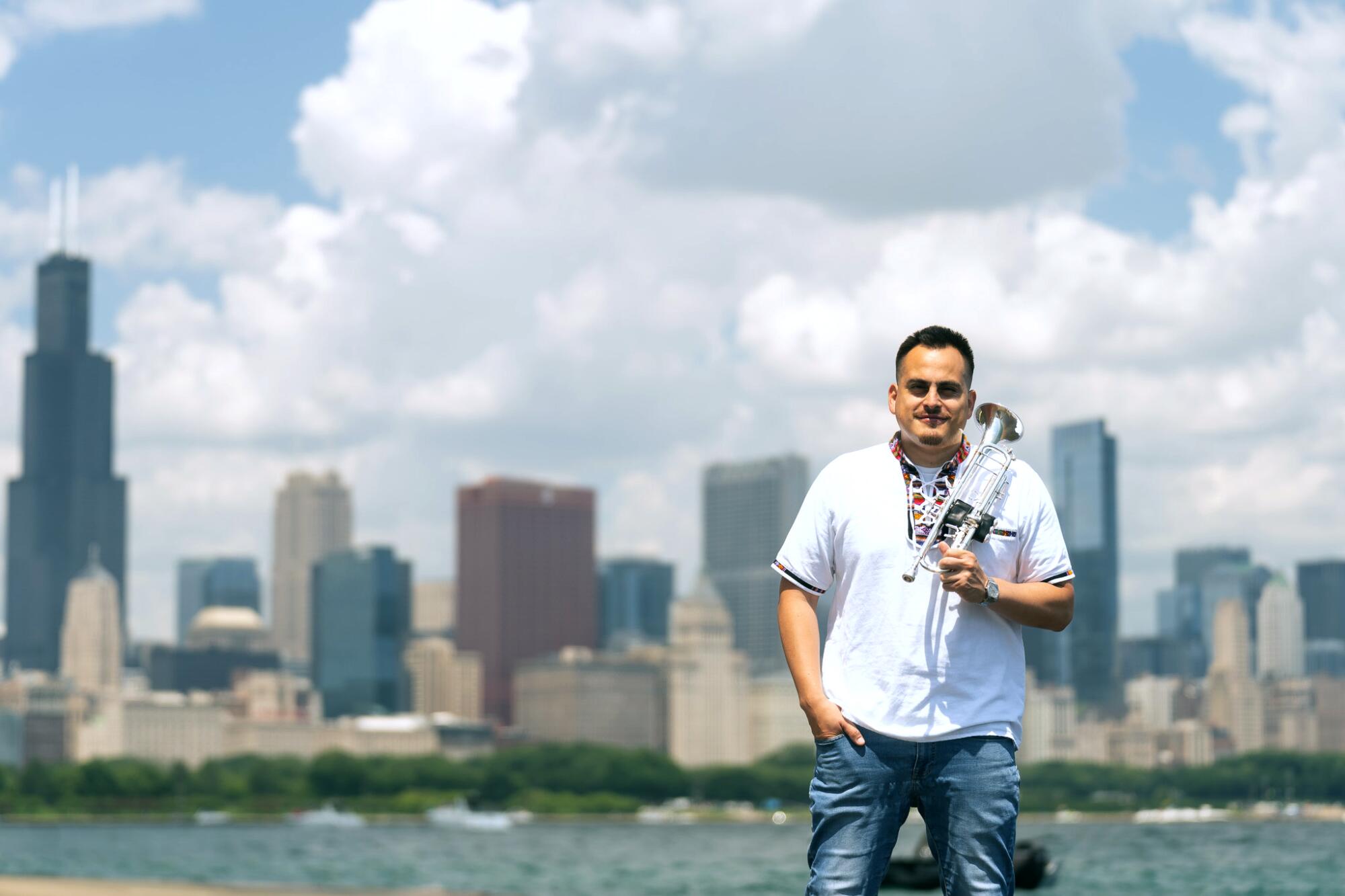 Trumpet player Daniel Flores poses with the Chicago skyline behind him