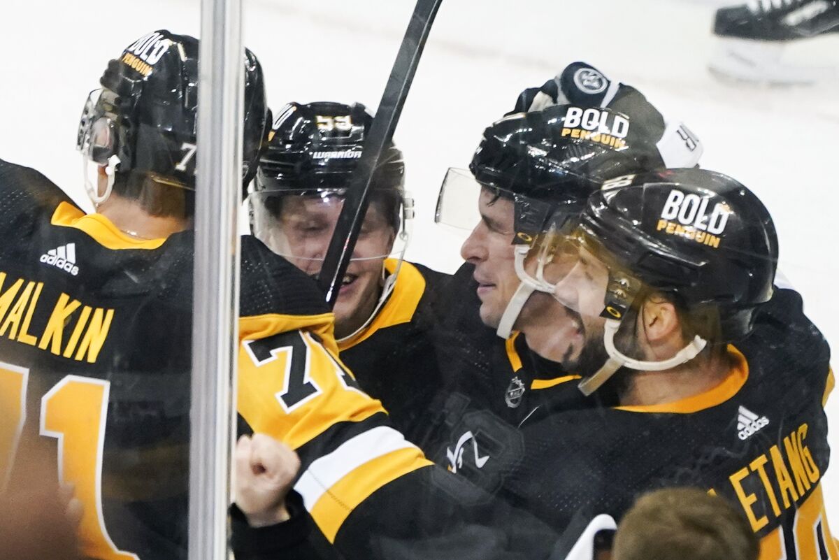 Pittsburgh Penguins' Sidney Crosby, center, right, celebrates with Jake Guentzel (59) , Kris Letang, and Evgeni Malkin (71) after he scored his 500th NHL career goal against the Philadelphia Flyers, during the first period of an NHL hockey game, Tuesday, Feb. 15, 2022, in Pittsburgh. (AP Photo/Keith Srakocic)