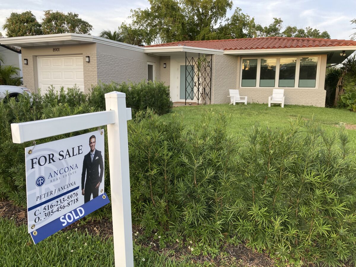 FILE - A home with a "Sold" sign is shown, Sunday, May 2, 2021, in Surfside, Fla. Average long-term U.S. mortgage rates retreated modestly this week, Thursday, May 19, 2022, but interest on the key 30-year loan remains at decade-high levels. (AP Photo/Wilfredo Lee, File)