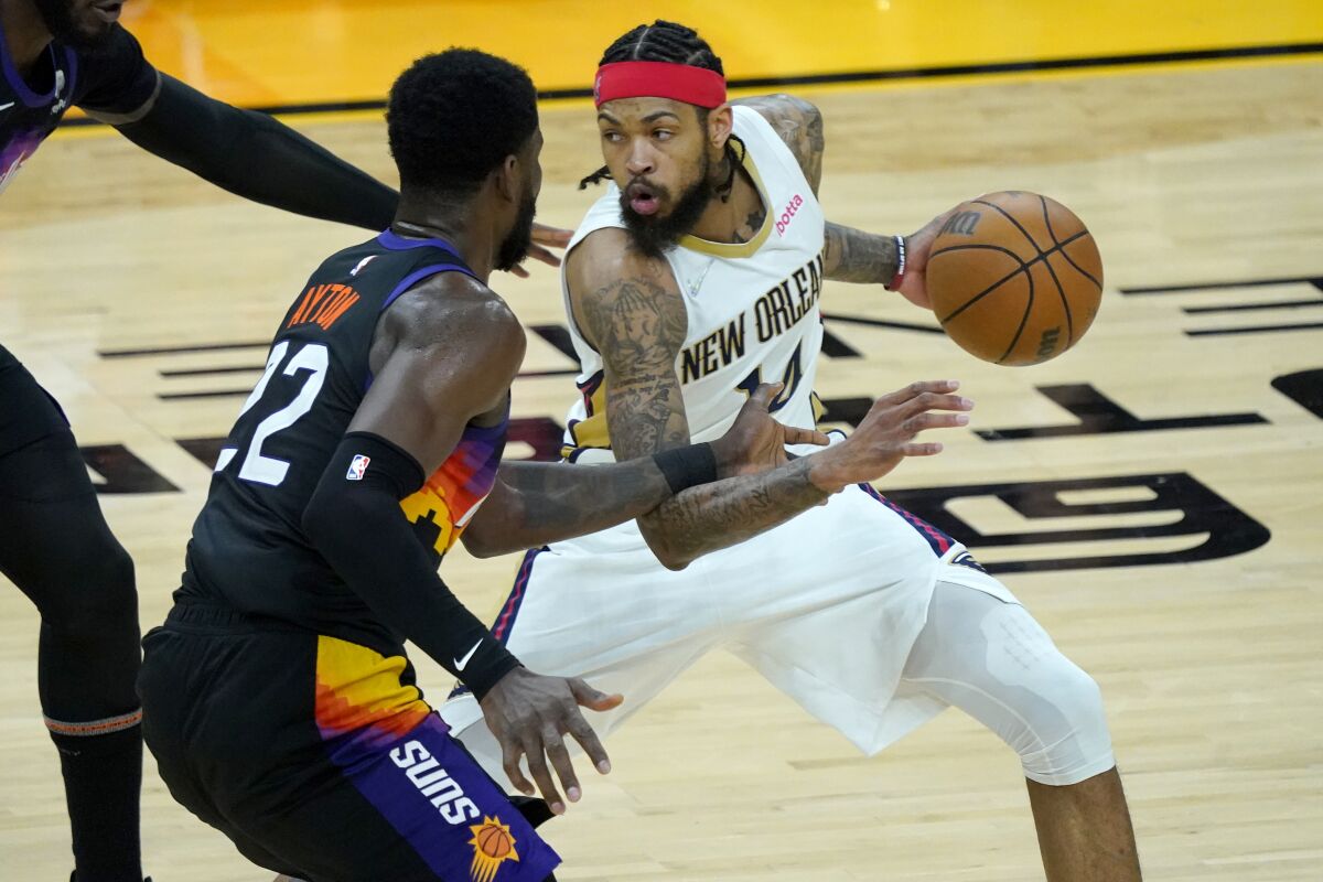 New Orleans Pelicans forward Brandon Ingram looks to pass as Phoenix Suns center Deandre Ayton defends.