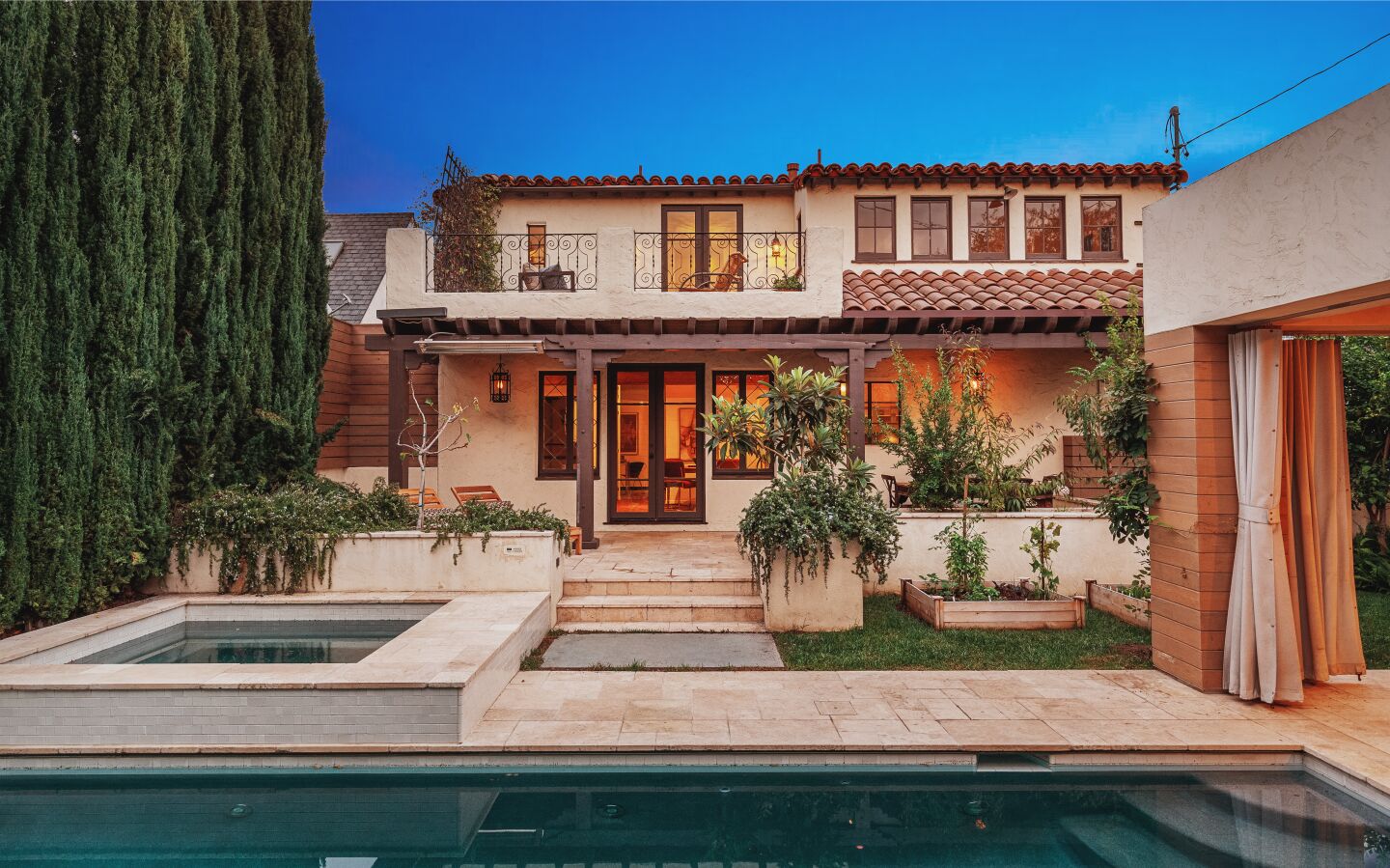 The backyard with a pool and a view of the house exterior and a cabana.