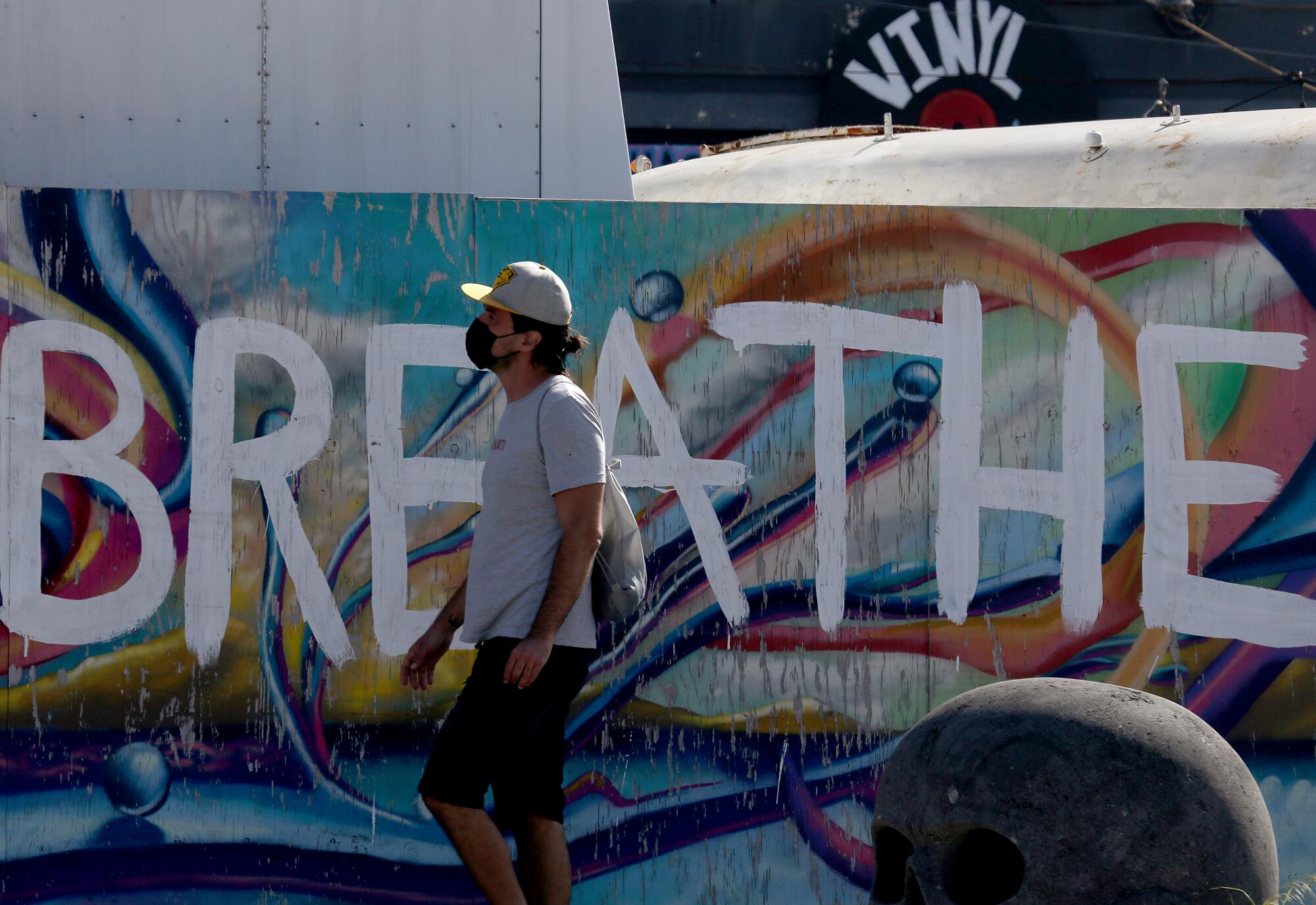 A pedestrian walks past a wall painted with George Floyd's final words, "I can't breathe," along Lincoln Boulevard in Venice.