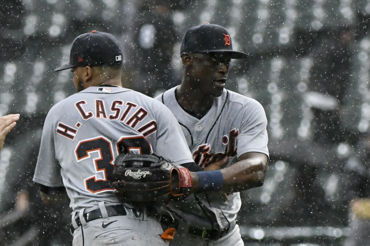 Detroit Tigers second baseman Harold Castro (30) and center fielder Daz Cameron, right, react in the rain at the end of a baseball game against the Chicago White Sox, Sunday, Oct. 3, 2021, in Chicago. (AP Photo/Matt Marton)