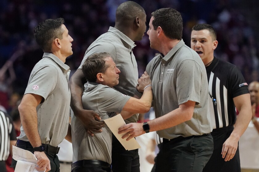 Arkansas head coach Eric Musselman is held back from the officials after being ejected in the second half of an NCAA college basketball game against Oklahoma, Saturday, Dec. 11, 2021, in Tulsa, Okla. (AP Photo/Sue Ogrocki)