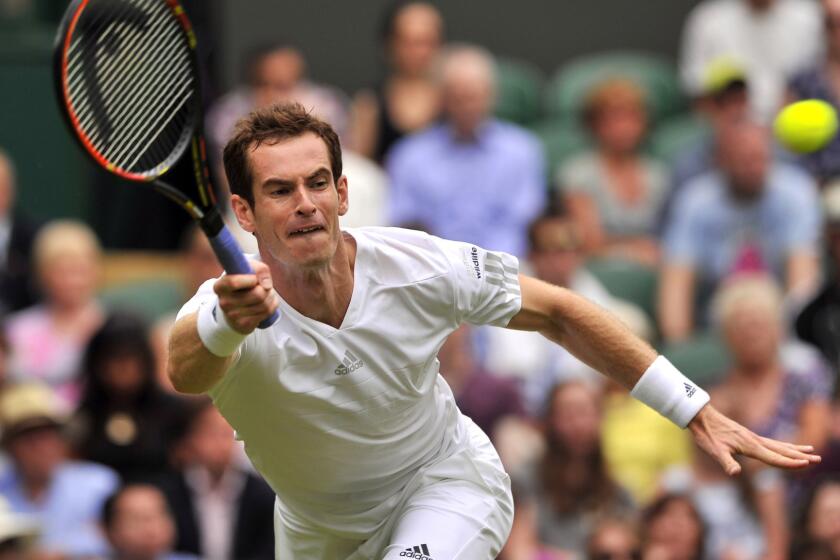 Andy Murray returns a shot during his first-round victory over David Goffin at Wimbledon on Monday.