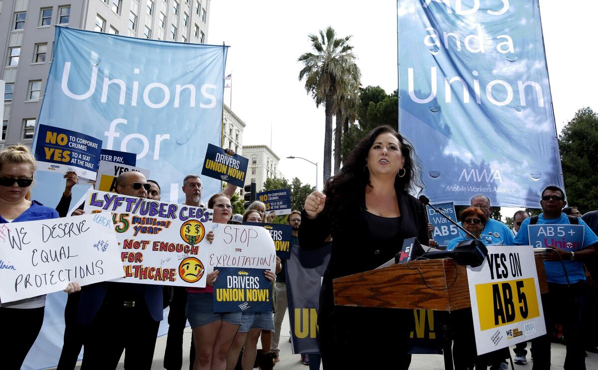 Lorena Gonzalez Fletcher stands among people holding pro-union signs.